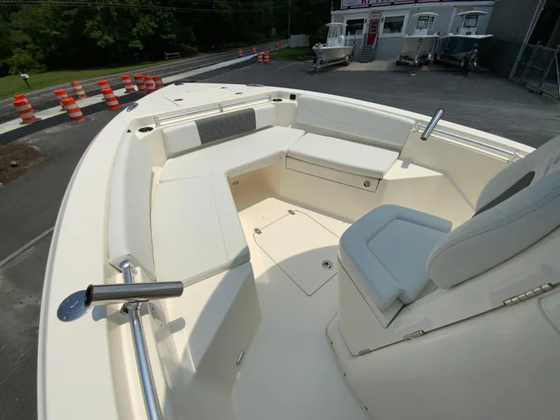 Slide: The Image of 2023 Cobia 240 Center Console boat interior with seating and storage, parked near roadwork. - 26
