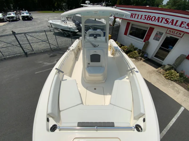 Slide: The Image of 2023 Cobia 240 Center Console boat at dealership, showcasing spacious deck and seating. - 27
