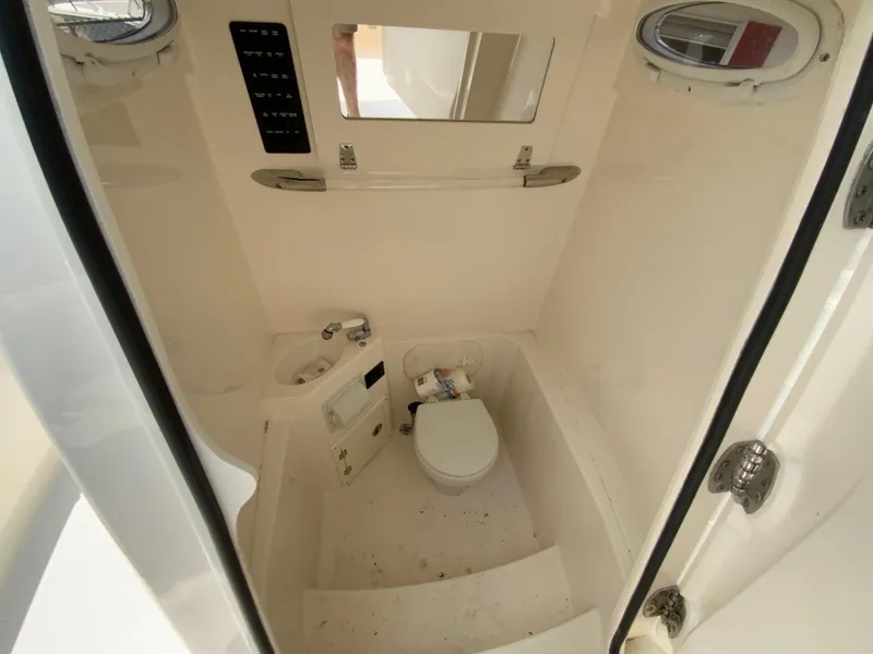 Slide: The Image of 2023 Cobia 240 Center Console boat interior with compact bathroom and toilet. - 31