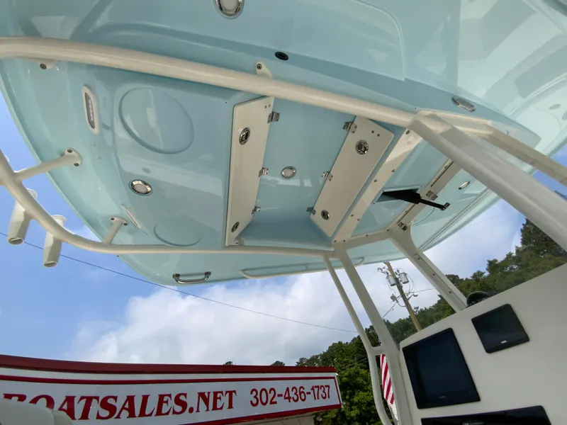 Slide: The Image of 2023 Cobia 240 Center Console boat with blue T-top and rod holders, viewed from below. - 32