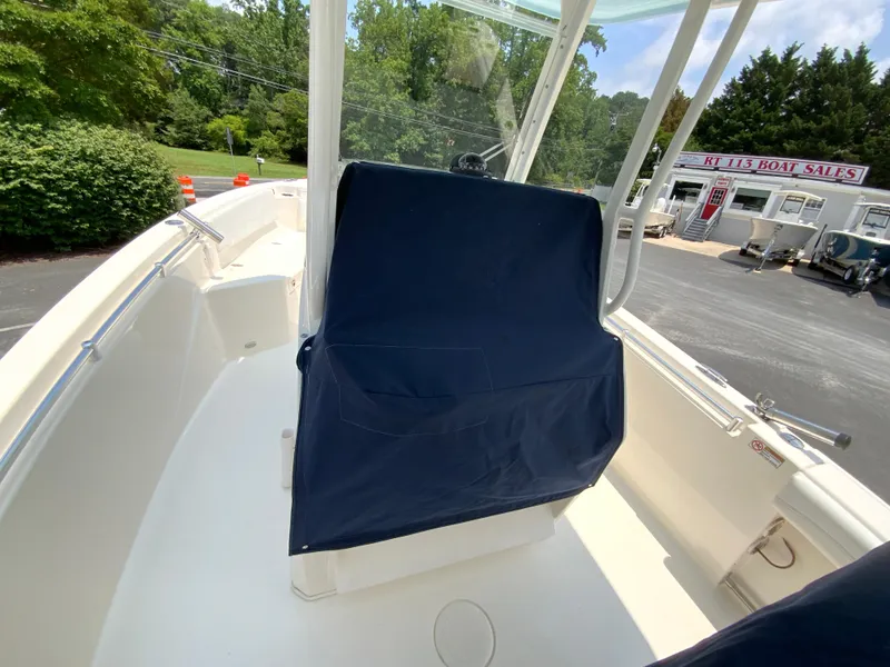 Slide: The Image of 2023 Cobia 240 Center Console boat interior at dealership, featuring covered seating and sleek design. - 34