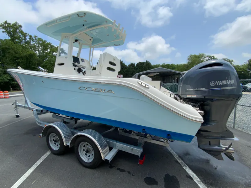 Slide: The Image of 2023 Cobia 240 Center Console boat on trailer with Yamaha engine, parked outdoors. - 7