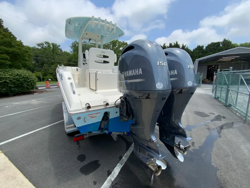 Slide: The Image of 2023 Cobia 240 Center Console boat with dual Yamaha 150 engines in a parking lot. - 8