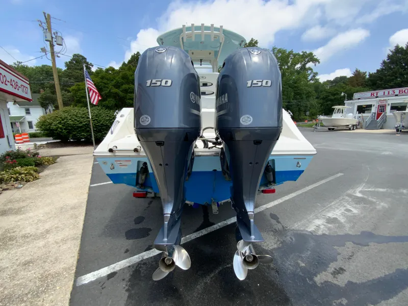 Slide: The Image of 2023 Cobia 240 Center Console with dual Yamaha 150 engines, parked outdoors. - 9