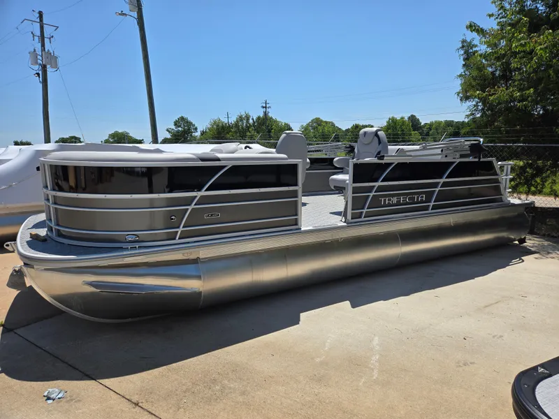 The Image of 2025 Trifecta 24 UL LET2.75 pontoon boat parked outdoors on a sunny day. - 1