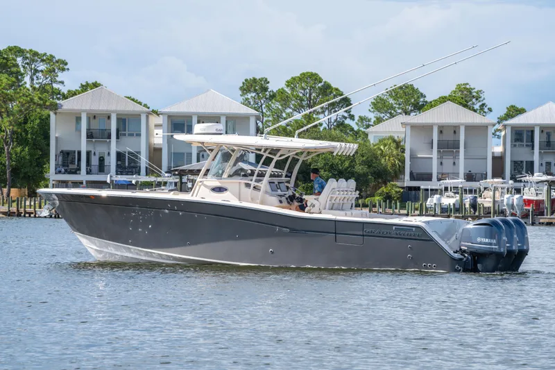 Slide: The Image of 2017 Grady-White 336 Canyon boat on water, with modern buildings in the background. - 11