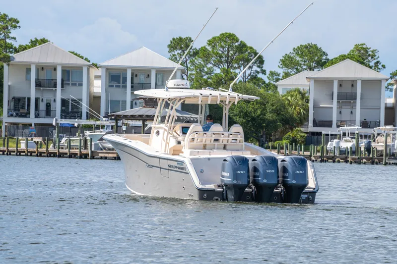 Slide: The Image of 2017 Grady-White 336 Canyon boat with triple Yamaha engines on a scenic waterfront. - 13