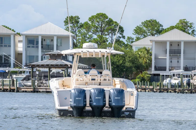 Slide: The Image of 2017 Grady-White 336 Canyon boat with triple Yamaha engines on water near docks. - 14