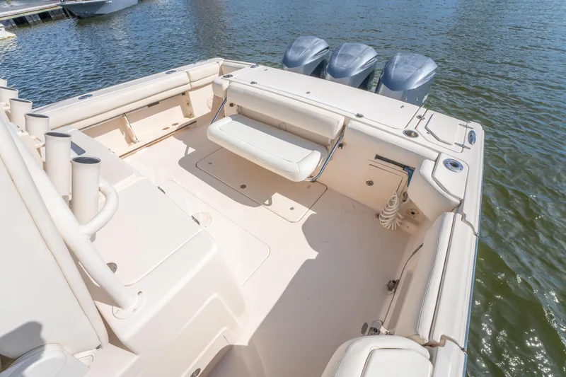 Slide: The Image of 2017 Grady-White 336 Canyon boat interior with seating and triple outboard motors. - 17