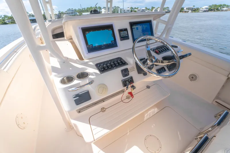 Slide: The Image of 2017 Grady-White 336 Canyon boat helm with navigation screens and steering wheel. - 26