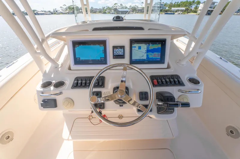 Slide: The Image of 2017 Grady-White 336 Canyon boat dashboard with navigation screens and steering wheel. - 27