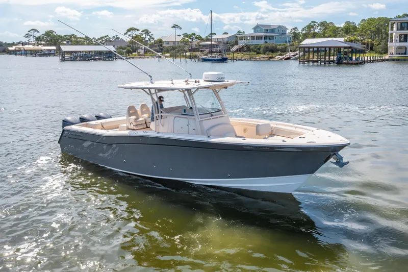 Slide: The Image of 2017 Grady-White 336 Canyon boat cruising on a sunny day near waterfront homes. - 3
