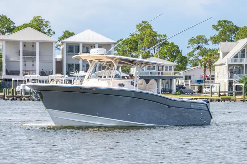 Slide: The Image of 2017 Grady-White 336 Canyon boat cruising near waterfront homes. - 8