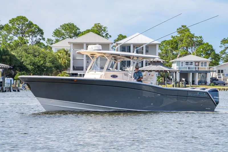 Slide: The Image of 2017 Grady-White 336 Canyon boat cruising near waterfront homes. - 9
