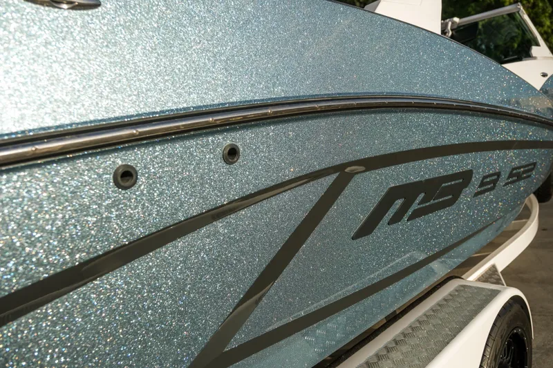 Slide: The Image of 2021 MB B23 Alpha boat with sparkling blue exterior on a trailer. - 12