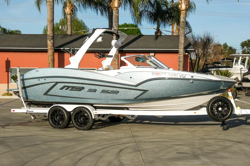 Slide: The Image of 2021 MB B23 Alpha boat on trailer, parked outdoors with palm trees in background. - 4