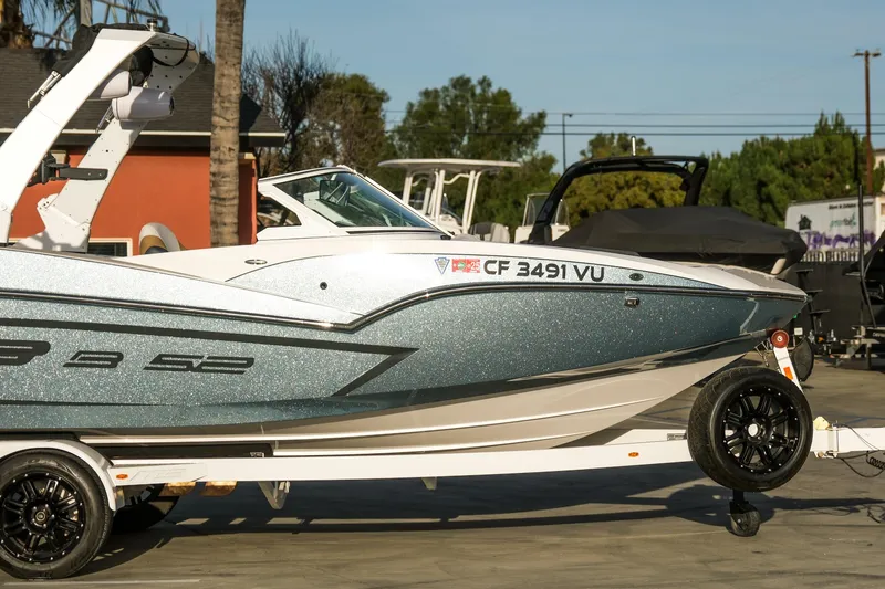 Slide: The Image of 2021 MB B23 Alpha boat on trailer, metallic finish, parked outdoors. - 6