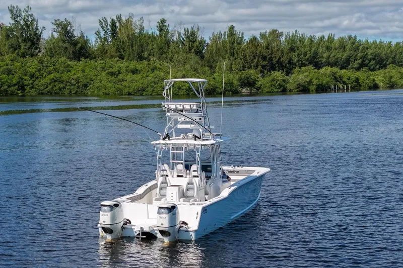 The Image of 2020 Tideline 365 Offshore boat on a serene lake with lush greenery. - 0