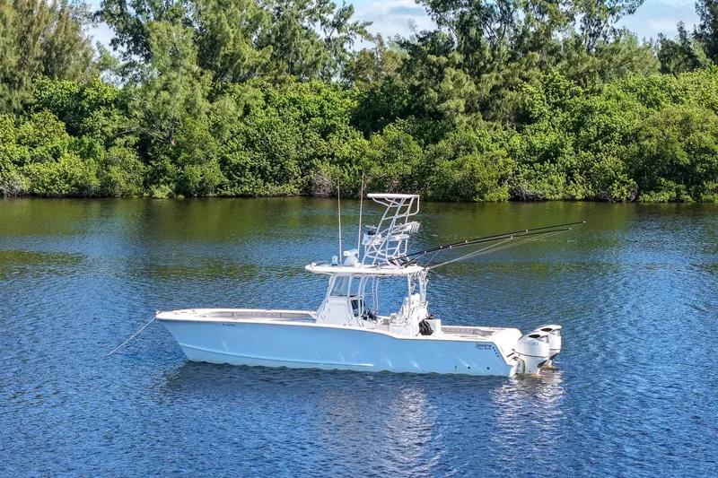 Slide: The Image of 2020 Tideline 365 Offshore boat on calm water, surrounded by lush greenery. - 10