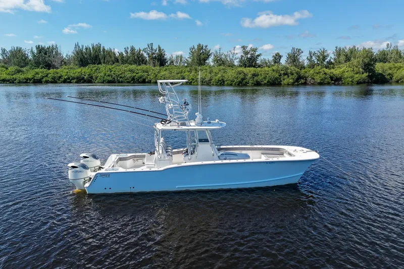 Slide: The Image of 2020 Tideline 365 Offshore boat on calm water, surrounded by lush greenery. - 3