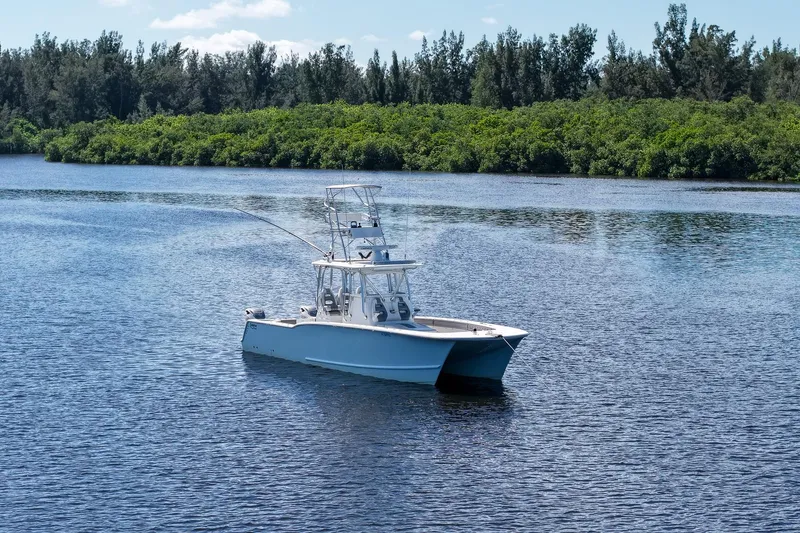 Slide: The Image of 2020 Tideline 365 Offshore boat on calm water with lush green shoreline. - 6
