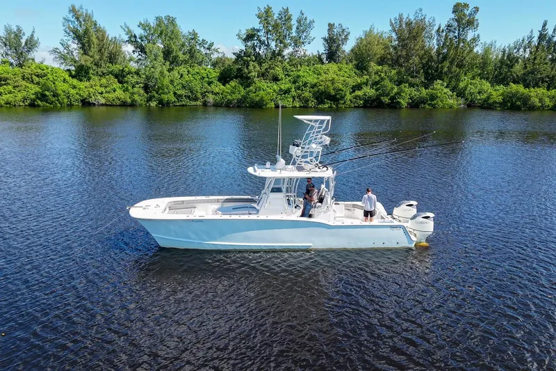 Slide: The Image of 2020 Tideline 365 Offshore boat on calm water, surrounded by lush greenery. - 72