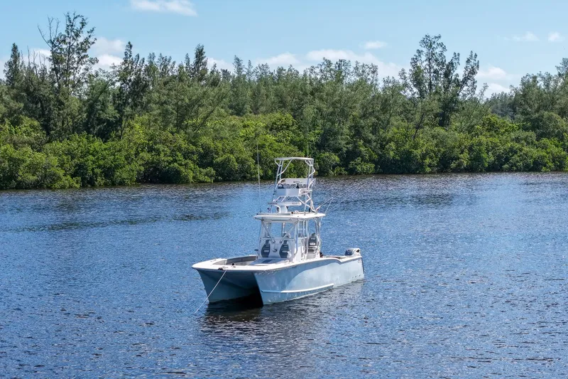 Slide: The Image of 2020 Tideline 365 Offshore boat on a serene lake with lush green trees. - 8
