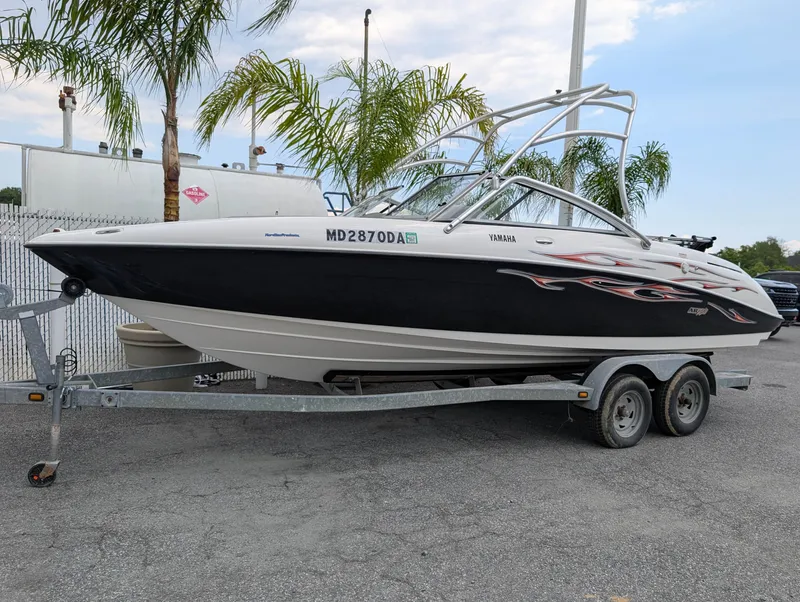 Slide: The Image of 2004 Yamaha Boats AR230 HO on trailer, parked near palm trees. - 2