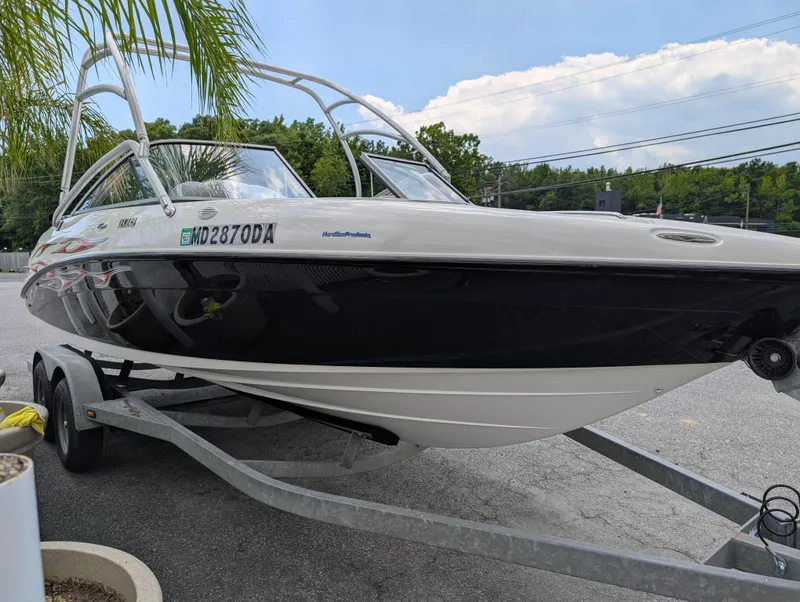 Slide: The Image of 2004 Yamaha AR230 HO boat on trailer, parked outdoors under clear sky. - 5