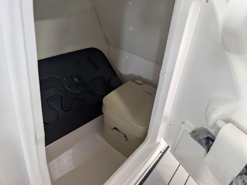 Slide: The Image of 2019 Yamaha Boats 242X E-Series interior with portable toilet and storage space. - 18