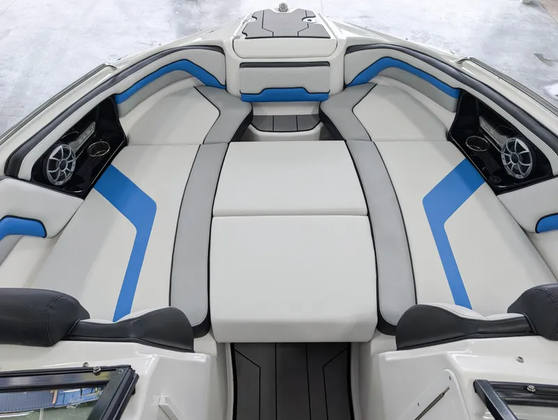 Slide: The Image of 2019 Yamaha Boats 242X E-Series interior with blue and gray seating, featuring speakers and cup holders. - 22