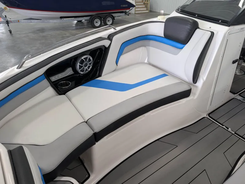 Slide: The Image of 2019 Yamaha Boats 242X E-Series interior with blue and gray seating, speaker, and cup holder. - 26