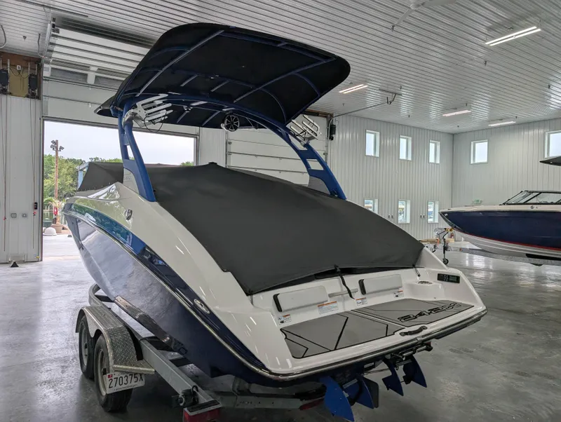 Slide: The Image of 2019 Yamaha Boats 242X E-Series in a garage, covered and on a trailer. - 28