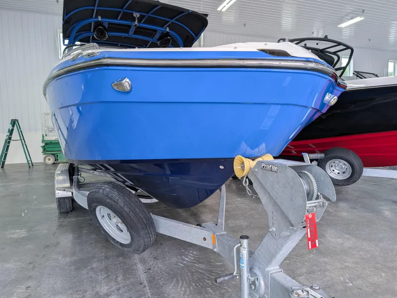 Slide: The Image of 2019 Yamaha Boats 242X E-Series in a showroom, blue hull on a trailer. - 3