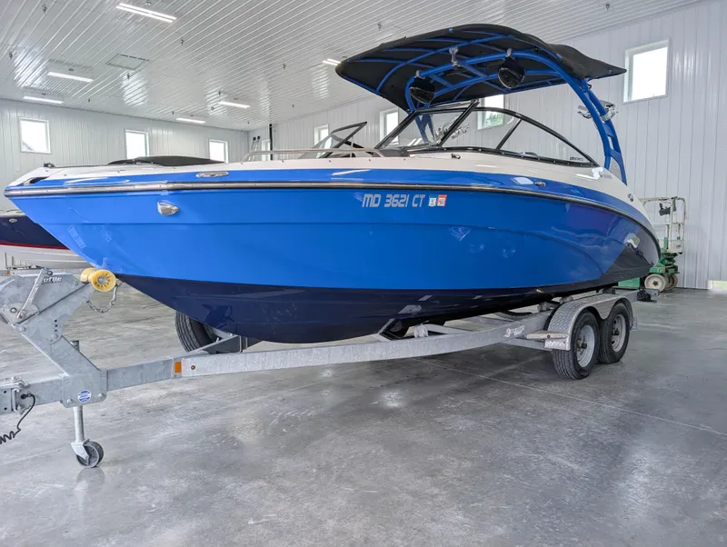 Slide: The Image of 2019 Yamaha Boats 242X E-Series in a garage, blue hull on a trailer. - 5