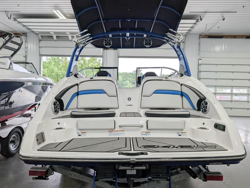 Slide: The Image of 2019 Yamaha Boats 242X E-Series in a showroom, showcasing rear seating and speakers. - 8