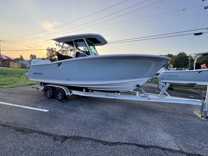 Slide: The Image of 2025 Blackfin 272 CC boat on trailer, parked outdoors at sunset. - 1