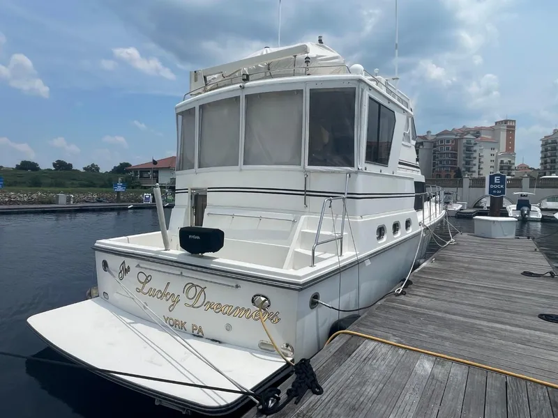 Slide: The Image of 2005 Novatec 48 Cockpit Motor Yacht docked at marina under cloudy sky. - 2