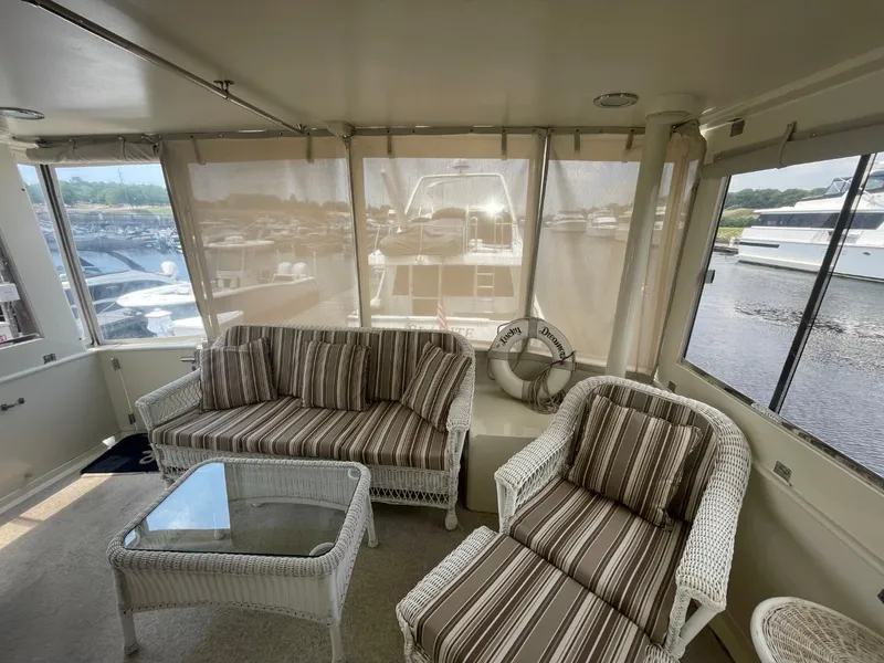 Slide: The Image of 2005 Novatec 48 Cockpit Motor Yacht interior with wicker furniture and marina view. - 21