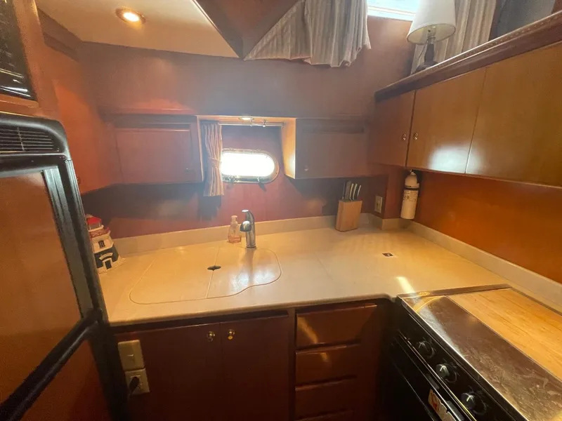 Slide: The Image of Galley kitchen in 2005 Novatec 48 Cockpit Motor Yacht with wooden cabinets and countertop. - 28