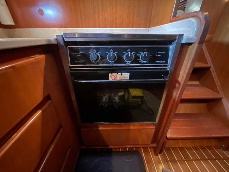 Slide: The Image of 2005 Novatec 48 Cockpit Motor Yacht kitchen with a built-in oven and wooden cabinetry. - 48