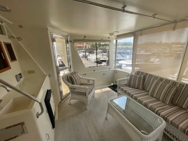 Slide: The Image of 2005 Novatec 48 Cockpit Motor Yacht interior with wicker furniture and marina view. - 9