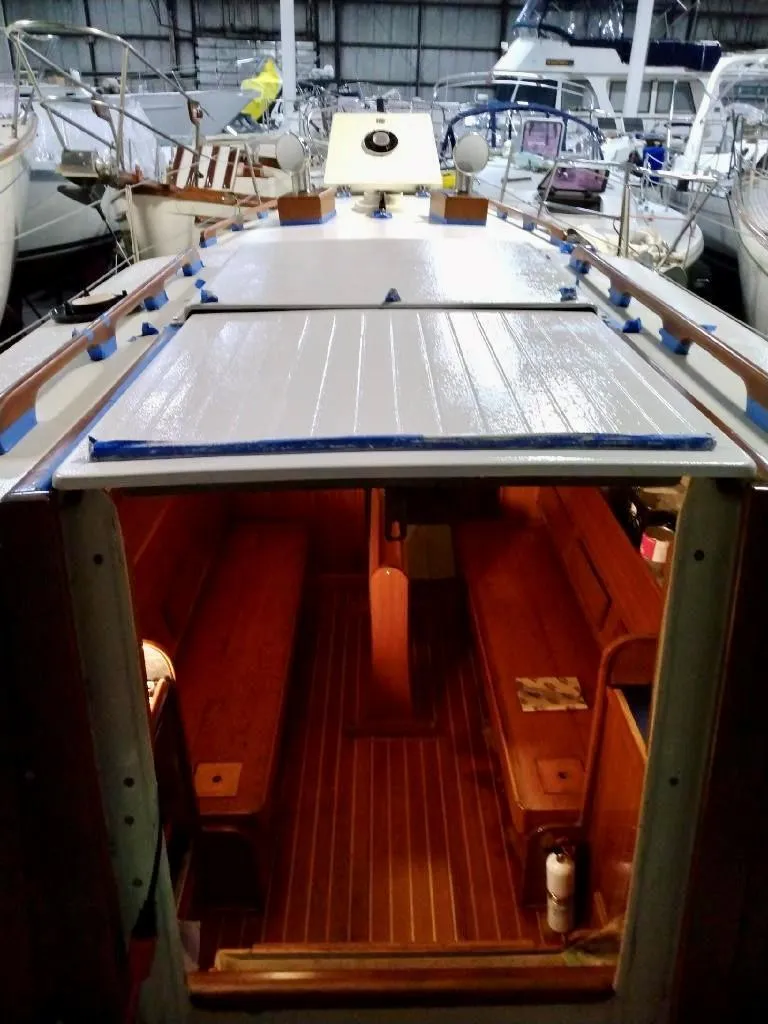 Slide: The Image of 1969 Chris-Craft Apache 37 boat interior with wooden seating and deck, docked in a marina. - 14