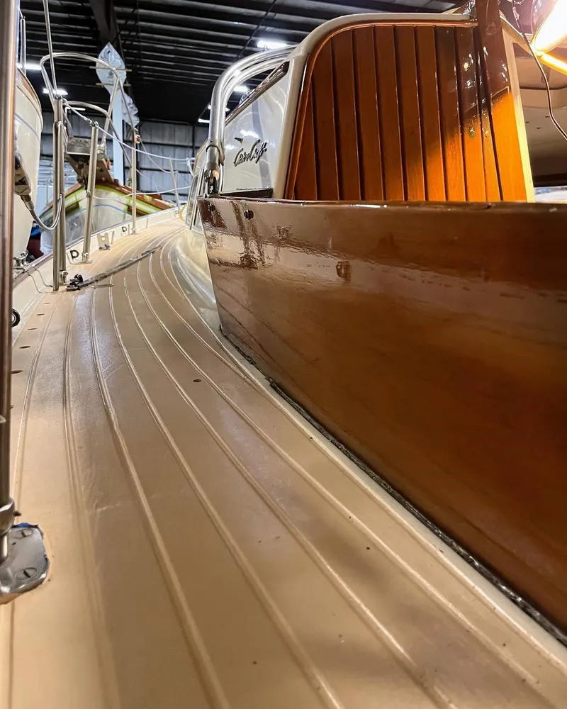 Slide: The Image of 1969 Chris-Craft Apache 37 boat with polished wood and sleek deck in a storage facility. - 16