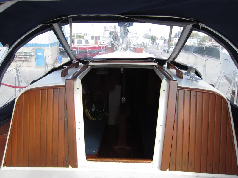 Slide: The Image of 1969 Chris-Craft Apache 37 sailboat cockpit with wooden hatch and marina view. - 17