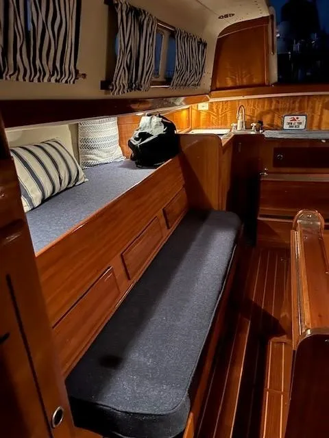 Slide: The Image of 1969 Chris-Craft Apache 37 interior with wood finish, striped curtains, and cozy seating. - 22