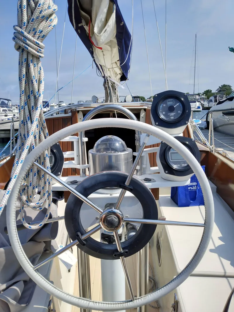 Slide: The Image of 1969 Chris-Craft Apache 37 sailboat helm with nautical instruments and rigging in a marina. - 8