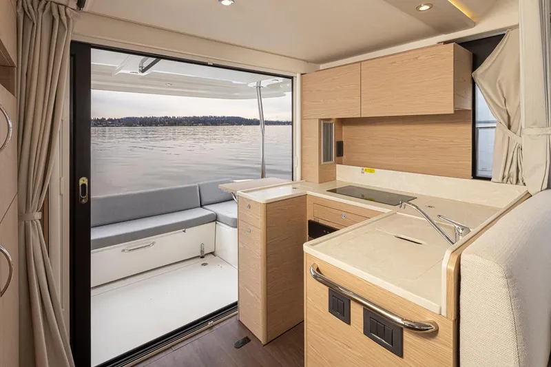 Slide: The Image of 2026 Beneteau Swift Trawler 41 Fly interior with modern kitchen and lake view. - 11