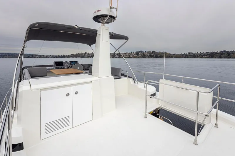 Slide: The Image of 2026 Beneteau Swift Trawler 41 Flybridge, spacious deck with seating, overlooking calm waters. - 18
