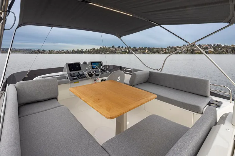 Slide: The Image of 2026 Beneteau Swift Trawler 41 Fly, spacious flybridge with seating and helm, overlooking serene waters. - 20